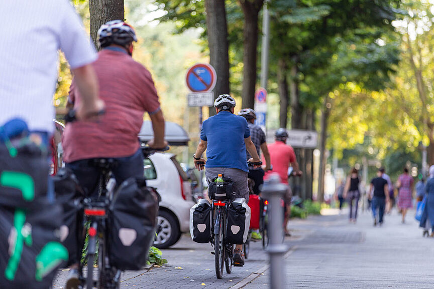 Berufsverkehr mit Fahrrad mehrere Personen auf dem Fahrradweg