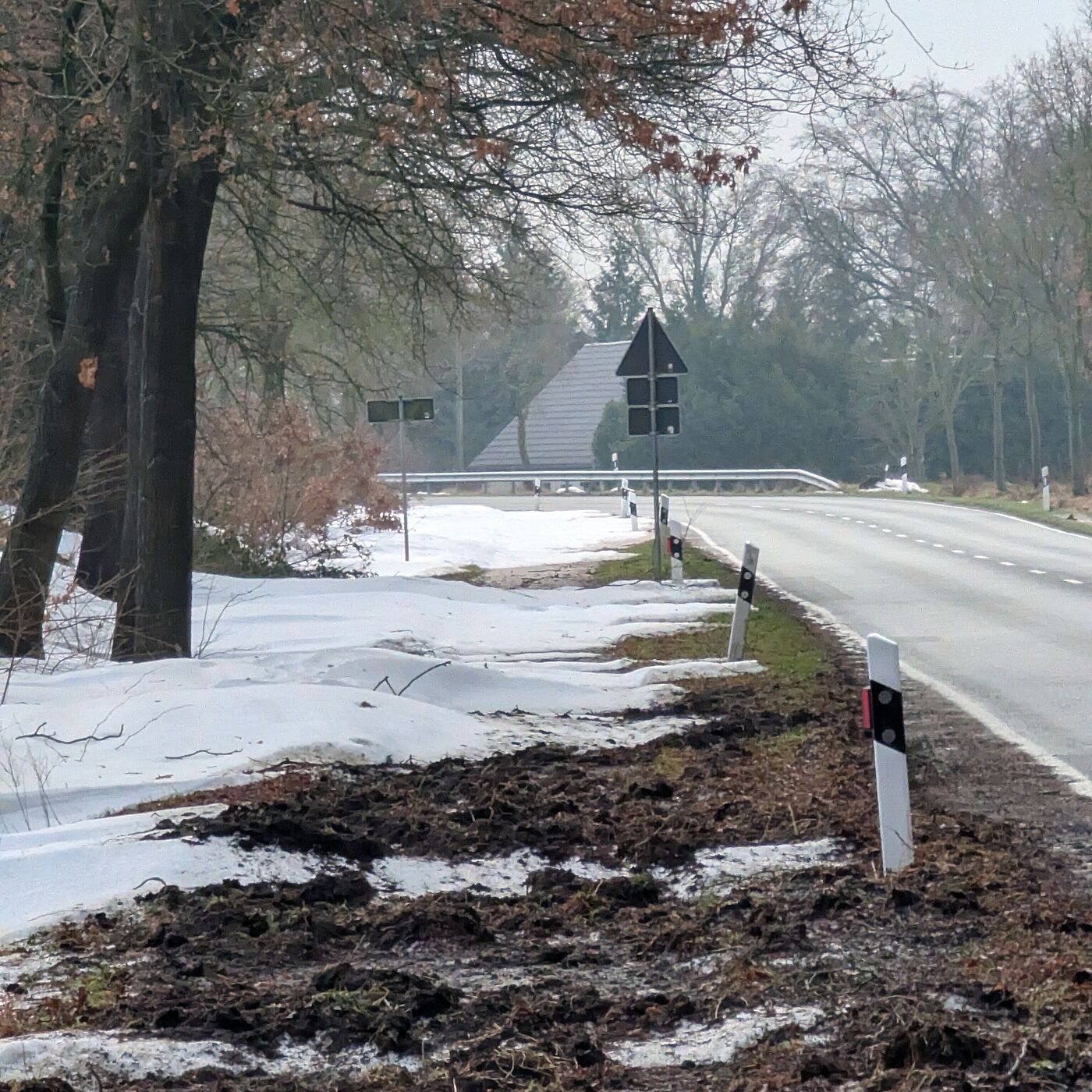 Ein Radweg komplett verdreckt mit Schnee und Erde, daneben eine schön geräumte Fahrbahn