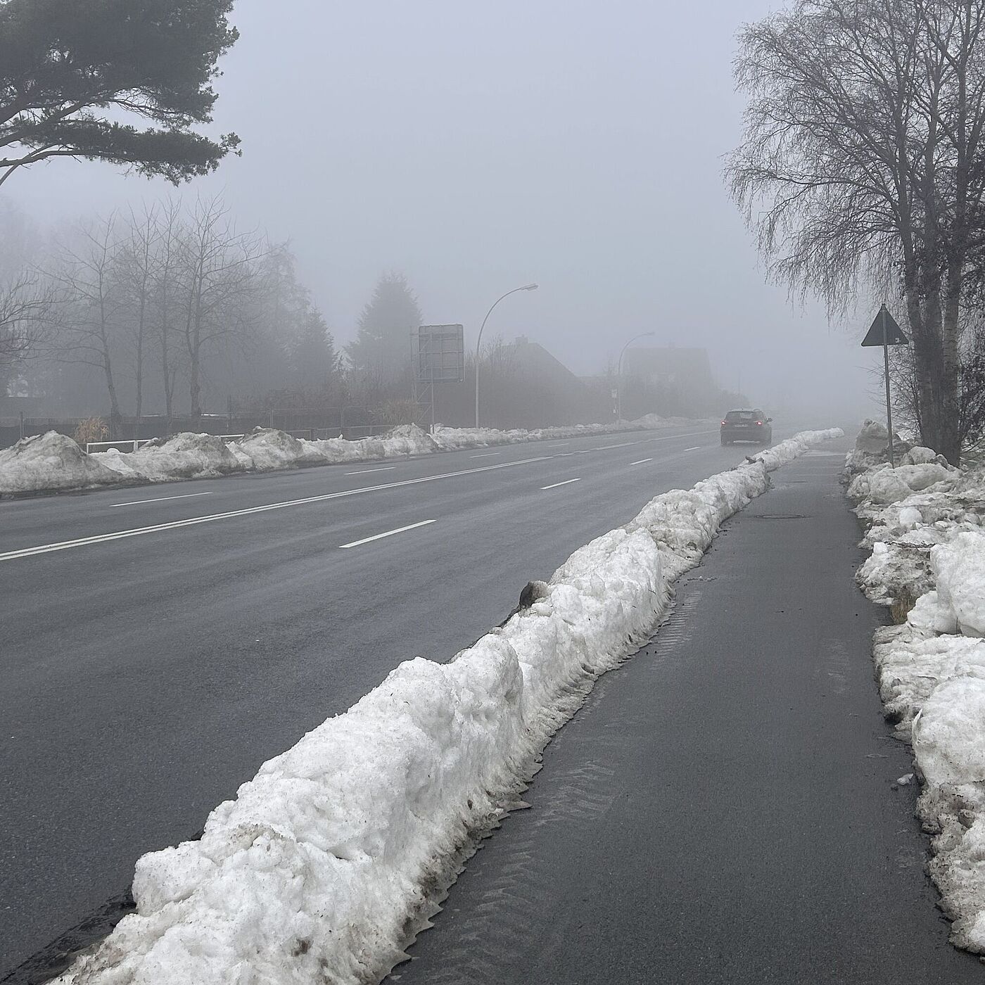 Ein geräumter Rad-/Fußweg auf einer Seite, auf der anderen Seite ein zugeschütteter Weg
