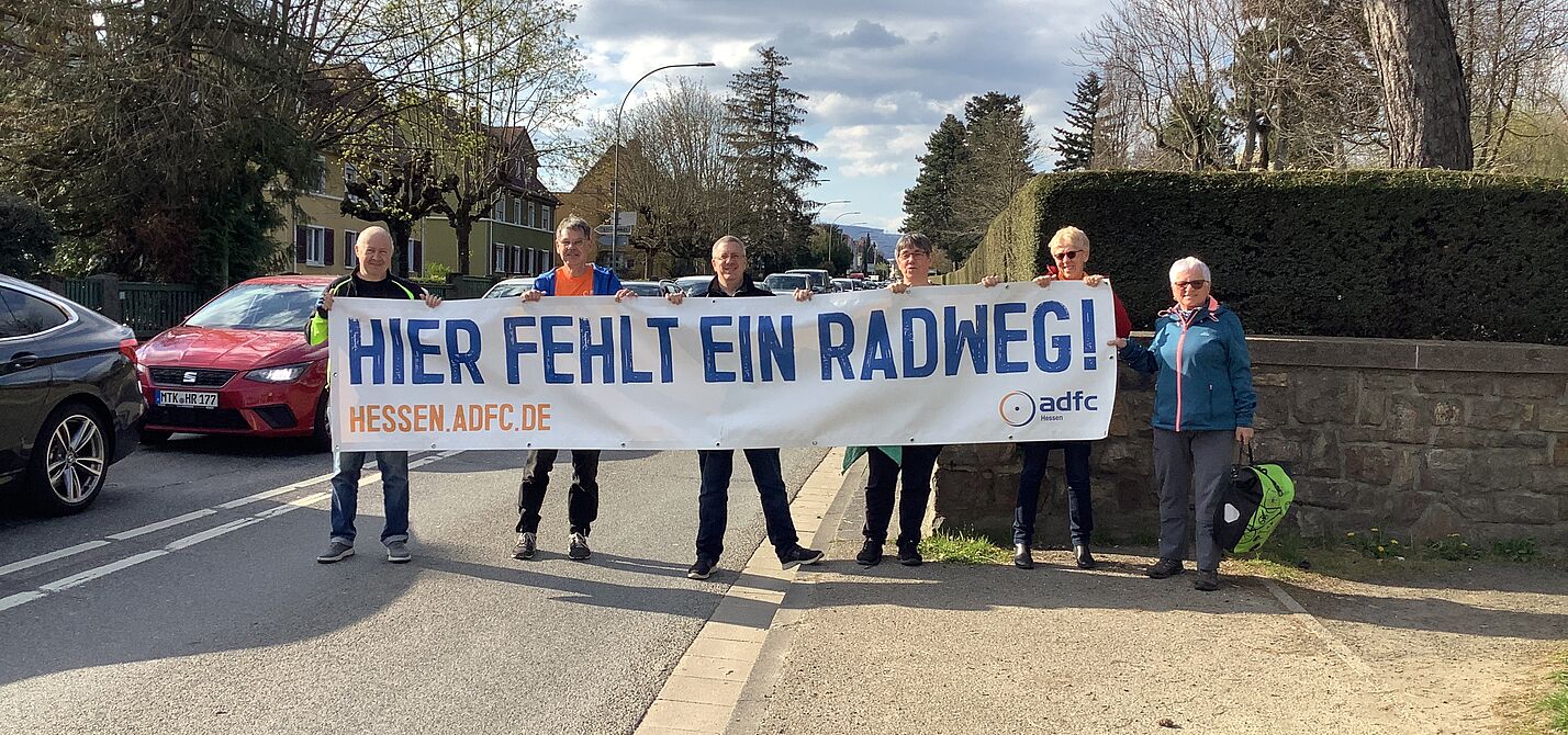 Frankfurter Landstraße: Radweg fehlt Personengruppe hält Banner hoch "Hier fehlt ein RAdweg"