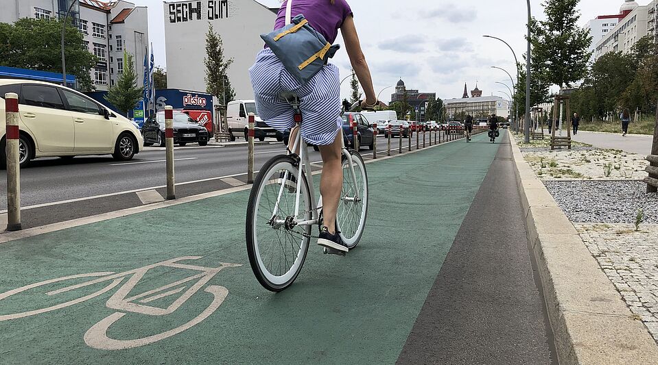 Frau auf geschütztem Radfahrstreifen Frau auf geschütztem Radfahrstreifen